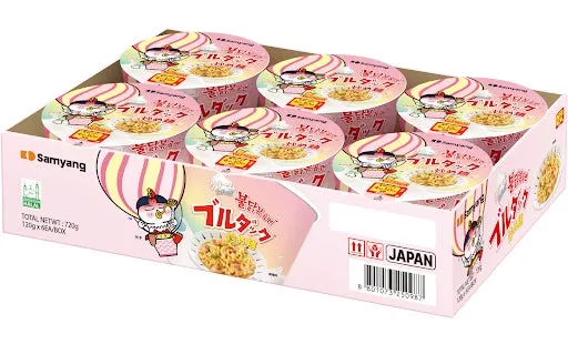 ピンク色の箱に入ったインスタントラーメン。箱には「ブルタック」の文字とキャラクターが描かれており、中にはカップラーメンが複数個入っている。