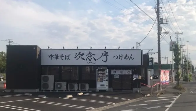 ラーメン屋の外観。看板には「中華そば 次念序 つけめん」と書かれている。