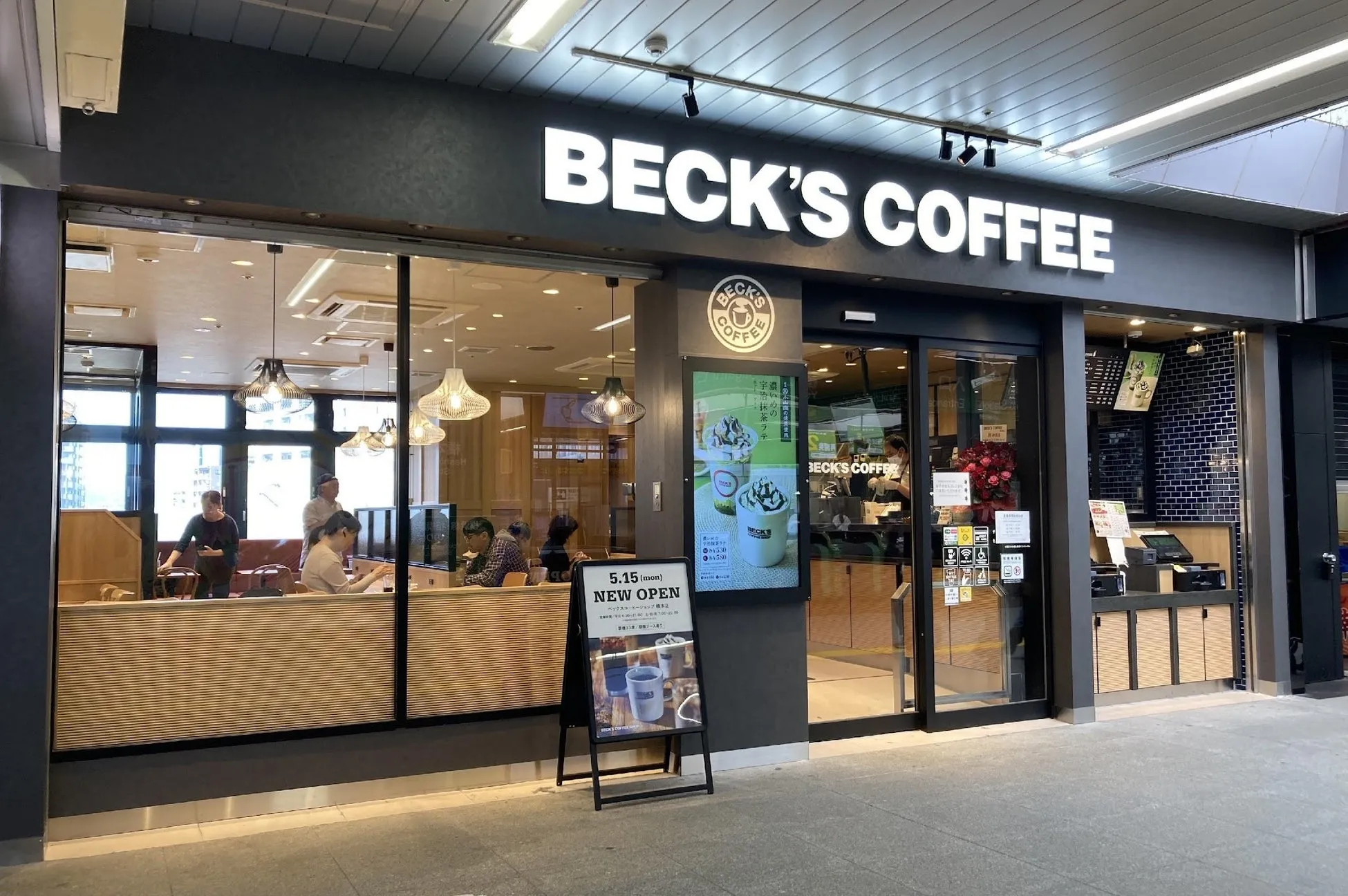 Beck's Coffeeの店舗の外観。看板には「BECK'S COFFEE」の文字と、新オープンの告知、メニューが表示されている。