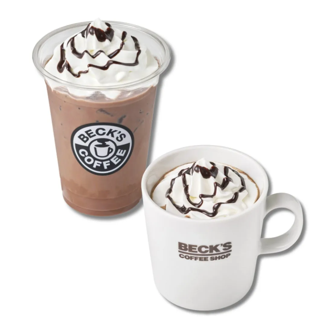 2つのチョコレートドリンク。1つは透明なカップに入ったアイスドリンク、もう1つは白いマグカップに入ったホットドリンク。どちらにもホイップクリームとチョコレートソースがトッピングされている。