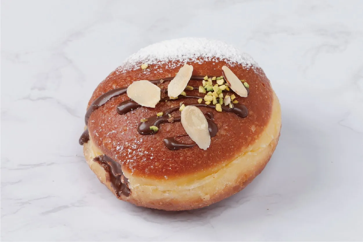 チョコレートソースとナッツがトッピングされたドーナツのクローズアップ写真。