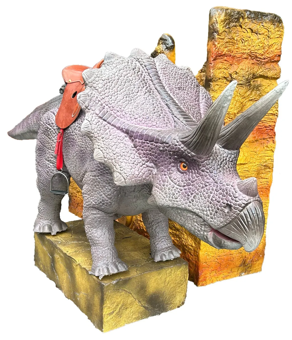 トリケラトプスの像。サドルが乗せられており、足元には岩のような台座がある。背景には岩壁が描かれている。