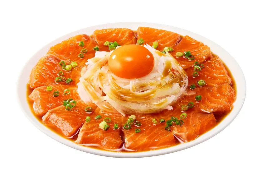 サーモンの刺身。真ん中に卵、玉ねぎ、ネギが添えられている。