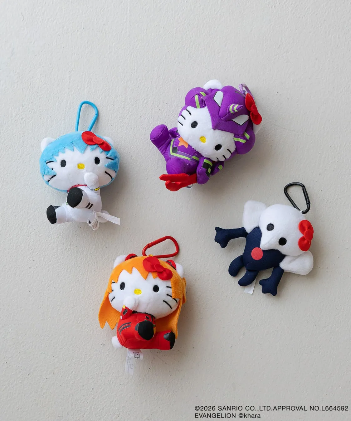 ハローキティとエヴァンゲリオンのコラボぬいぐるみ。青いハローキティは宇宙服、紫のハローキティはエヴァンゲリオンのパイロットスーツ、オレンジ色のハローキティはアスカ、白と紺色のハローキティは使徒をモチーフにしている。
